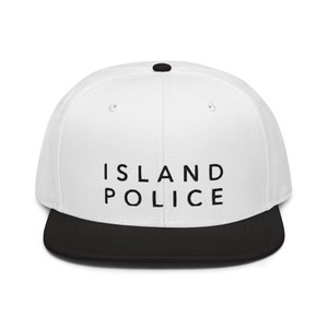 May include: White and black baseball cap with the text "ISLAND POLICE" in black lettering.