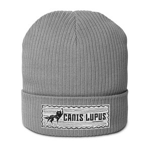 May include: Gray knitted beanie with a white patch featuring a black wolf silhouette and the text "Canis Lupus".