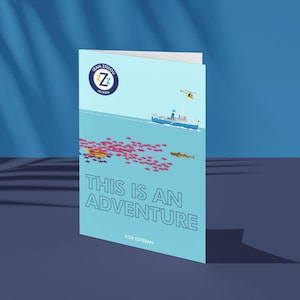 May include: A light blue greeting card with the text "THIS IS AN ADVENTURE" and "FOR ESTEBAN". The card features an illustration of a ship, helicopter, and marine life. The Team Zissou logo is in the upper left corner.
