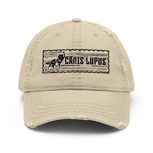 May include: A beige distressed baseball cap with a black and white graphic of a wolf and the text "Canis Lupus" on the front.