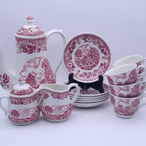 May include: A vintage tea set with a pink floral pattern. The set includes a teapot, creamer, sugar bowl, and four teacups and saucers.
