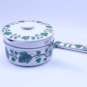 May include: White porcelain double boiler with a green ivy pattern. The lid has a small knob and a spout. The handle is silver with a green ivy pattern.