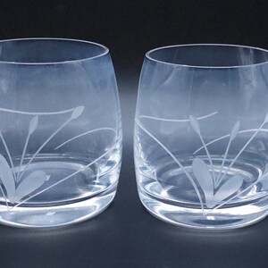 Peut inclure: Deux verres &agrave; boire en verre transparent avec un motif grav&eacute; de feuilles et de tiges stylis&eacute;es.
