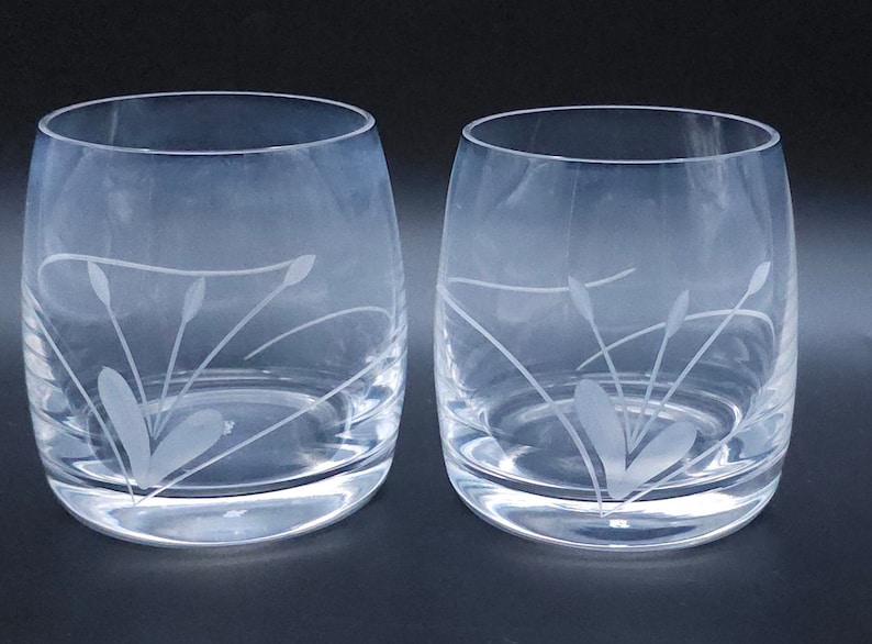 Peut inclure: Deux verres &agrave; boire en verre transparent avec un motif grav&eacute; de feuilles et de tiges stylis&eacute;es.