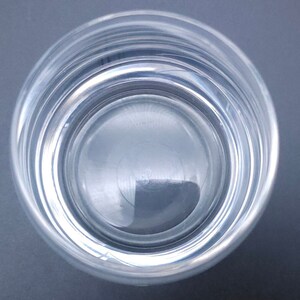 Peut inclure: Un verre en verre transparent rempli d'eau. L'eau est calme et refl&egrave;te la lumi&egrave;re.