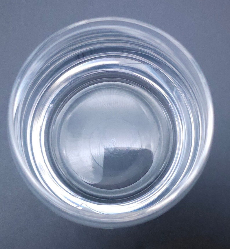 Peut inclure: Un verre en verre transparent rempli d'eau. L'eau est calme et refl&egrave;te la lumi&egrave;re.