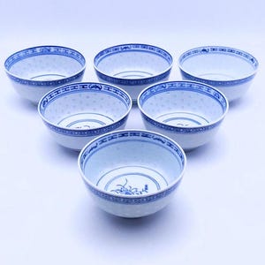 May include: Set of six white porcelain bowls with blue and white floral designs. The bowls have a classic Chinese design with a blue rim and a white interior.