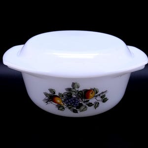 Op de afbeelding: Witte keramische ovenschaal met deksel. De schaal heeft een bloemmotief met fruit en druiven.