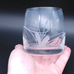 Peut inclure: Un verre &agrave; boire en verre transparent avec un motif floral grav&eacute;. Le verre a un fond arrondi et une large ouverture.