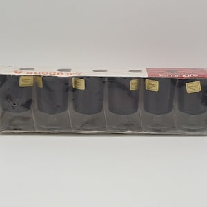 Op de afbeelding: Een doos met zes zwarte Luminarc shotglazen. De doos is wit met rode en zwarte tekst die "6 suodo n. 7 Luminarc" luidt.