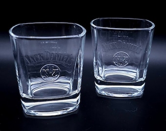 May include: Two clear glass tumblers with the Jack Daniel's logo etched on the front. The logo includes the words "Jack Daniel's" and "Old No. 7 Brand Tennessee Whiskey".