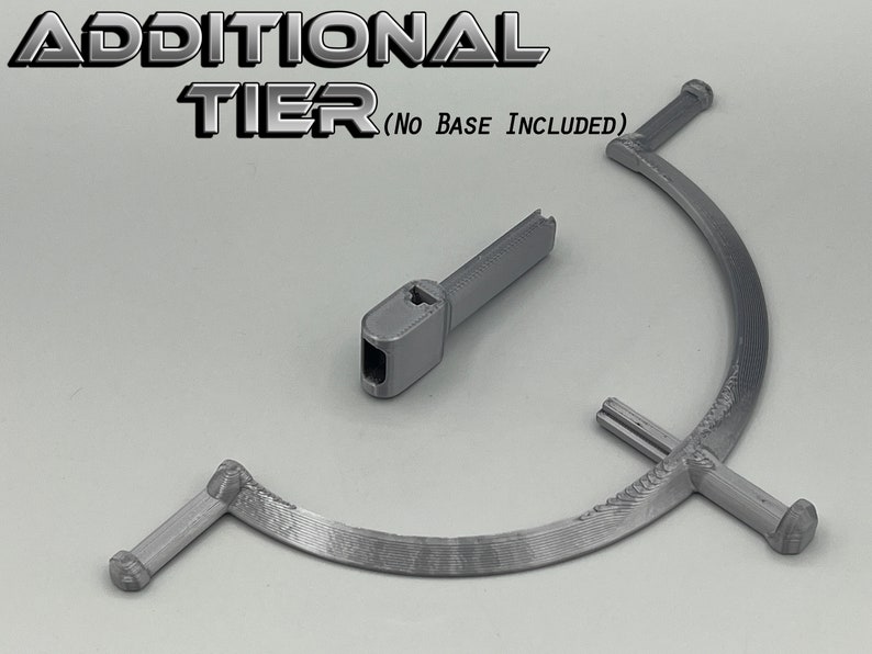 May include: Two gray 3D printed pieces for a tiered stand. The larger piece is a curved, three-pronged base. The smaller piece is a straight connector.  ADDITIONAL TIER (NO BASE INCLUDED) is printed on the image.