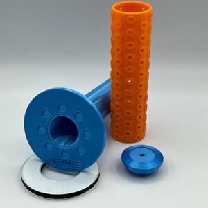 May include: A blue and orange 3D printed set of parts for a 3D printer. The set includes a blue base with a hole in the center, a blue cap, a blue and orange tube, and a white ring with black trim.