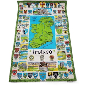 May include: A rectangular tea towel featuring a map of Ireland in the center, surrounded by various colorful illustrations of Irish landmarks, castles, and regional coats of arms. The text Ireland is printed in the lower center of the fabric.