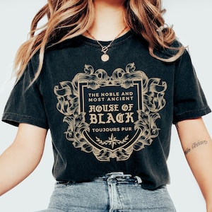 May include: A black t-shirt with a gold graphic design featuring a crest with the text "The Noble and Most Ancient House of Black, Toujours Pur".