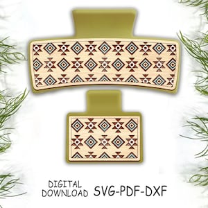 May include: A green hair clip with a geometric pattern in brown, blue, and white. The pattern is reminiscent of Native American art.