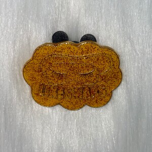 Könnte beinhalten: Goldfarbener Metallstift in Form einer Wolke mit dem Wort "Hey Girl" in Glitzer geschrieben.