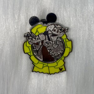 May include: A silver pin with a yellow ribbon design. The pin features a cartoon character with a long tail and a Mickey Mouse head.