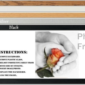 May include: A black picture frame with a white mount and a black and white photograph of hands holding a rose. The text "INSTRUCTIONS:" is printed on the mount with instructions on how to insert a photo into the frame. The text "Photo in Framez" is printed on the bottom right corner of the frame.