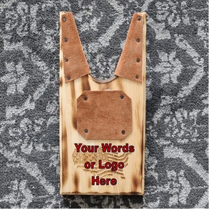 May include: Wooden boot jack with leather inserts and a burned design of the American flag. The text "Your Words or Logo Here" is engraved below the flag.