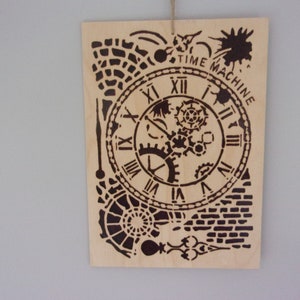 May include: Wooden wall art featuring a black time machine design. The design includes a clock face with Roman numerals, gears, and the words "TIME MACHINE". The art is made of light-colored wood and is hanging by a string.