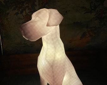 Può includere: Una scultura di cane geometrica stampata in 3D di colore bianco con una luce all'interno. La scultura è seduta su una superficie con un motivo.
