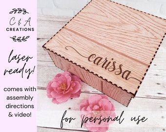 May include: A wooden box with a laser-cut design, featuring the name "carissa" on the lid. The box has a light brown wood grain pattern and is accompanied by pink flowers. Text on the image says "laser ready!" and "for personal use."