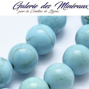 May include: A strand of light blue turquoise beads. The beads are round and smooth, with a slightly mottled appearance.