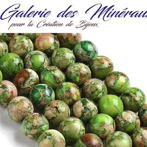 Puede incluir: Una hebra de cuentas de jaspe verde y marrón. Las cuentas son redondas y tienen un aspecto moteado.