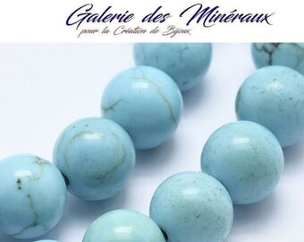 May include: A strand of light blue turquoise beads. The beads are round and smooth, with a slightly mottled appearance.