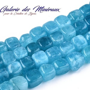 May include: A strand of light blue square-shaped gemstone beads. The beads are smooth and polished, with a slightly translucent appearance.