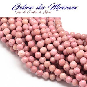 Può includere: Primo piano di una collezione di perline rotonde rosa. Le perline sono di un colore rosa tenue con variazioni di tonalità. L'immagine include il testo "Galerie des Minéraux pour la Création de Bijoux". Queste perline sono adatte per la creazione di gioielli.