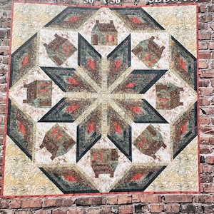 May include: A quilt pattern called "Cabin in the Woods" with a starburst design featuring small houses in the centre. The quilt is 50 inches by 50 inches and has a 3DDC-146 design code.