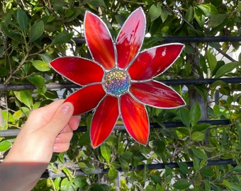 Flor roja con una vidriera iridiscente en el centro del arco iris