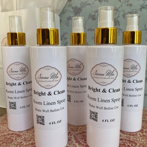 May include: Five white bottles of room linen spray with gold lids and labels. The labels have the text "Savon Mio" and "Bright & Clean Room Linen Spray". Each bottle contains 4 fl oz.