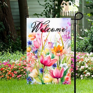 May include: A welcome garden flag with a watercolor design of colorful flowers, including tulips, and the word "Welcome" in black script.