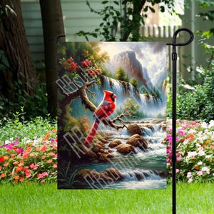 May include: A garden flag with a red cardinal perched on a branch near a waterfall. The background is a painting of a lush forest with a mountain in the distance.