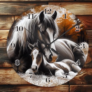 May include: Round wall clock featuring a detailed illustration of a mother horse and foal. The clock face displays black numbers against a background of the horses and a rustic, wooden texture.