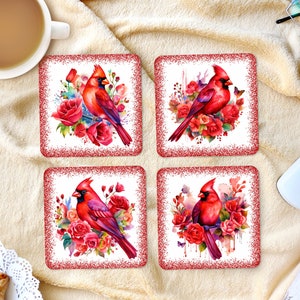May include: Set of four red and white coasters featuring a cardinal bird perched on a branch with red roses. The coasters have a glittery red border.