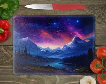 May include: A glass cutting board with a colorful mountain scene and a starry night sky. The mountains are covered in snow and the sky is filled with stars and a galaxy. The cutting board is perfect for adding a touch of nature to your kitchen.