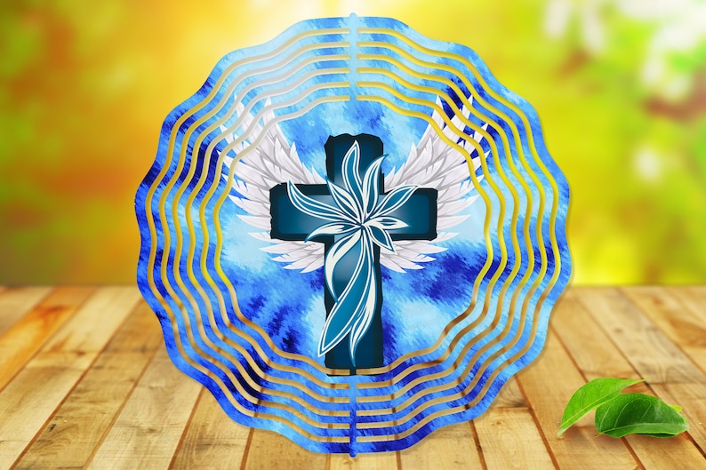 May include: A blue and white metal wind spinner with a cross and wings design. The cross is blue with a white flower design and white wings. The background is a blue and white watercolor pattern.