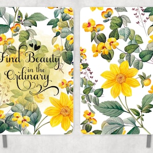 May include: A white notebook with a floral design featuring yellow flowers and green leaves. The front cover has the text "Find Beauty in the Ordinary" in black cursive font.