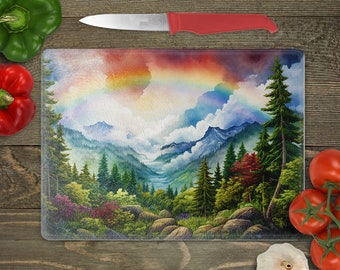 May include: A glass cutting board with a colorful rainbow over a mountain landscape. The mountains are covered in green trees and fog. The sky is a mix of blue, purple, and orange.