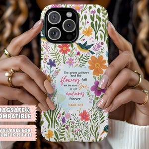 以下が含まれることがあります： カラフルな花、緑の葉、小さな鳥が描かれた、白いiPhoneケース。ケースには「The grass withers and the flowers fall but the word of our God endures Forever Isaiah 40:8」の文字が書かれています。