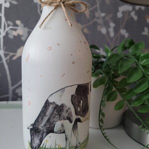 Decorative speckled bottle perfect for country style kitchens. Featuring a painted style dairy cow design