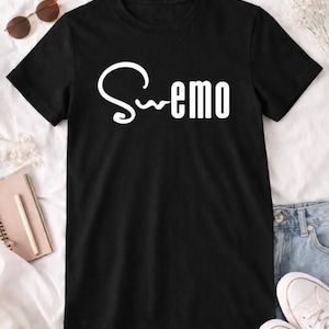 Könnte beinhalten: Schwarzes T-Shirt mit dem Wort "Swemo" in weißer, stilisierter Schrift. Das Shirt wird auf einer weißen Oberfläche mit Sonnenbrille, Notizbuch, Stift und weißen Turnschuhen präsentiert.