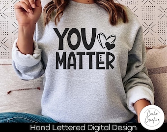 Puede incluir: Una sudadera gris con el texto "YOU MATTER" en letras negras y un gráfico de corazón negro.