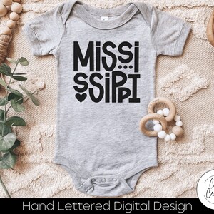 May include: A gray baby onesie with black text that reads "MISSISSIPPI" with a small heart in front of the word "SIPI".