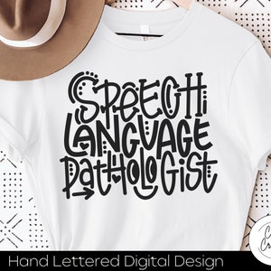 Op de afbeelding: Wit T-shirt met zwarte tekst die "Speech Language Pathologist" luidt in een handschrift stijl.