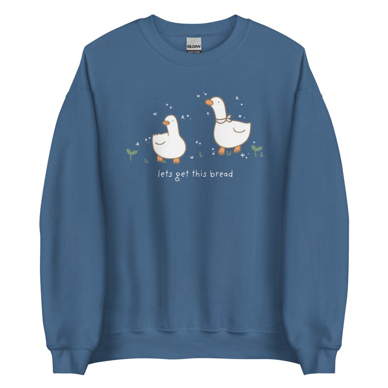 Indigo Blue Whimsical Duck Sweatshirt with a dtg printed design of two ducks surrounded by sparkles, and below it says " lets get this bread"